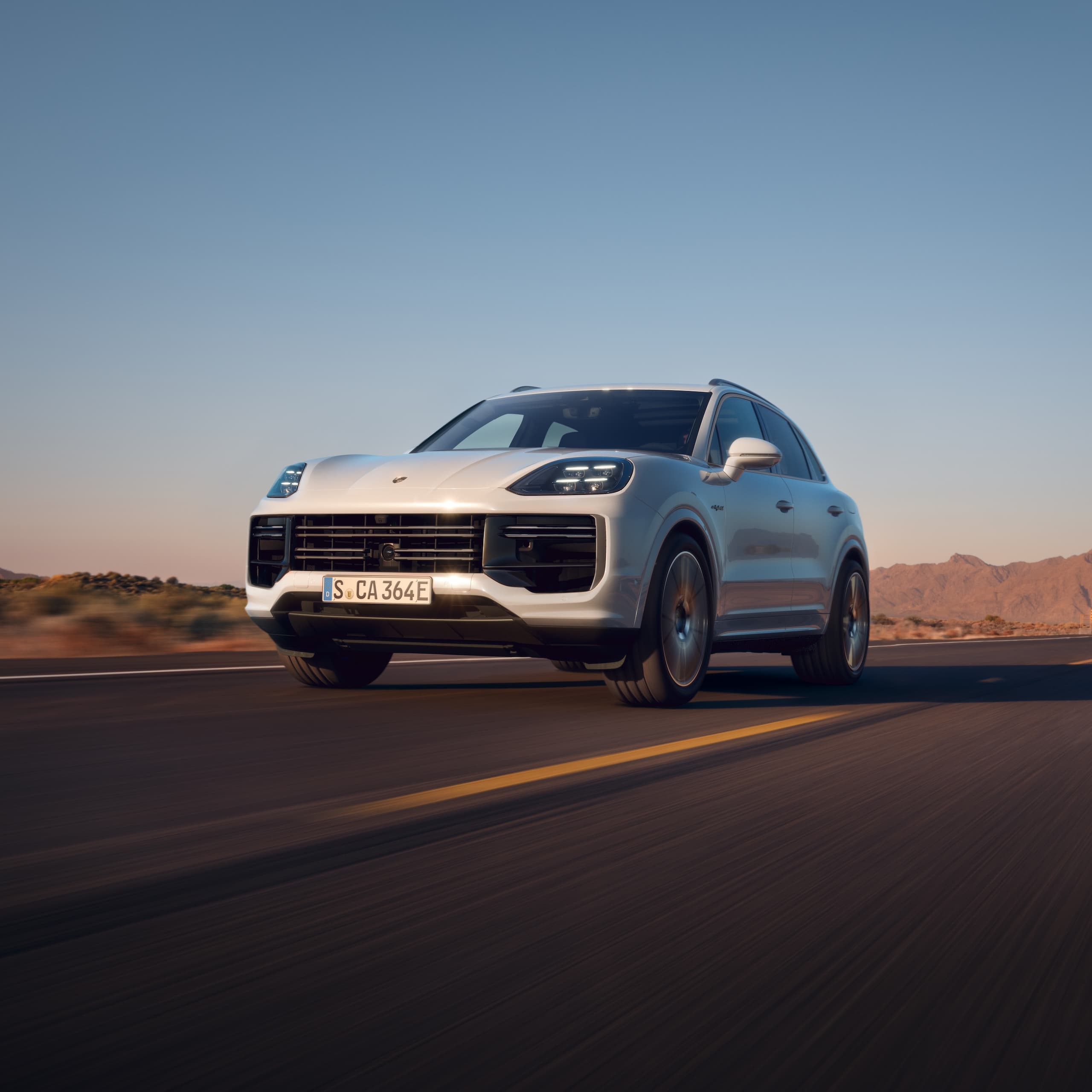 A Porsche Cayenne driving on an open road.